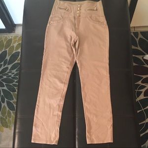 Tan skinny pants button fly and zipper opening elastic waist.
